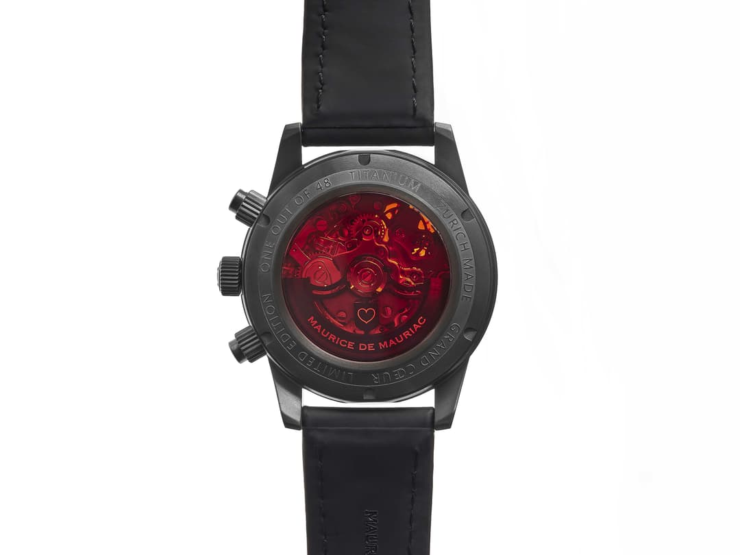 Montre Grand Cœur des frères Dreifuss, boîtier titane gris foncé avec bracelet noir, cadran rouge transparent révélant le mouvement mécanique