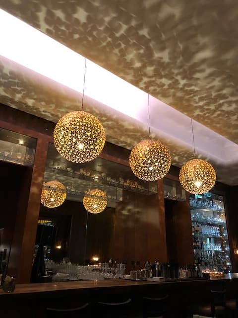 Luminaires dorés en forme de boules suspendus au-dessus du bar du Lobby Lounge du Beau-Rivage Palace