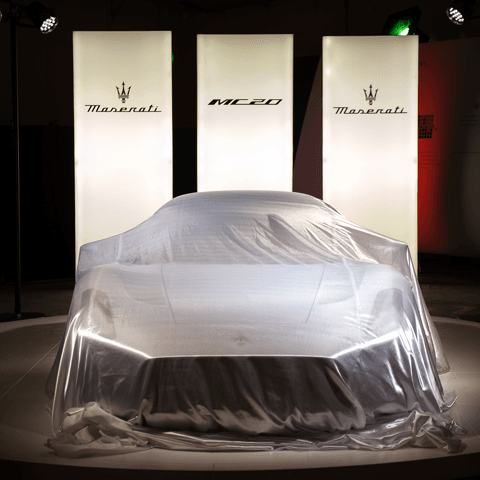Maserati MC20 recouverte d'une bâche blanche lors de sa présentation à des clients suisses