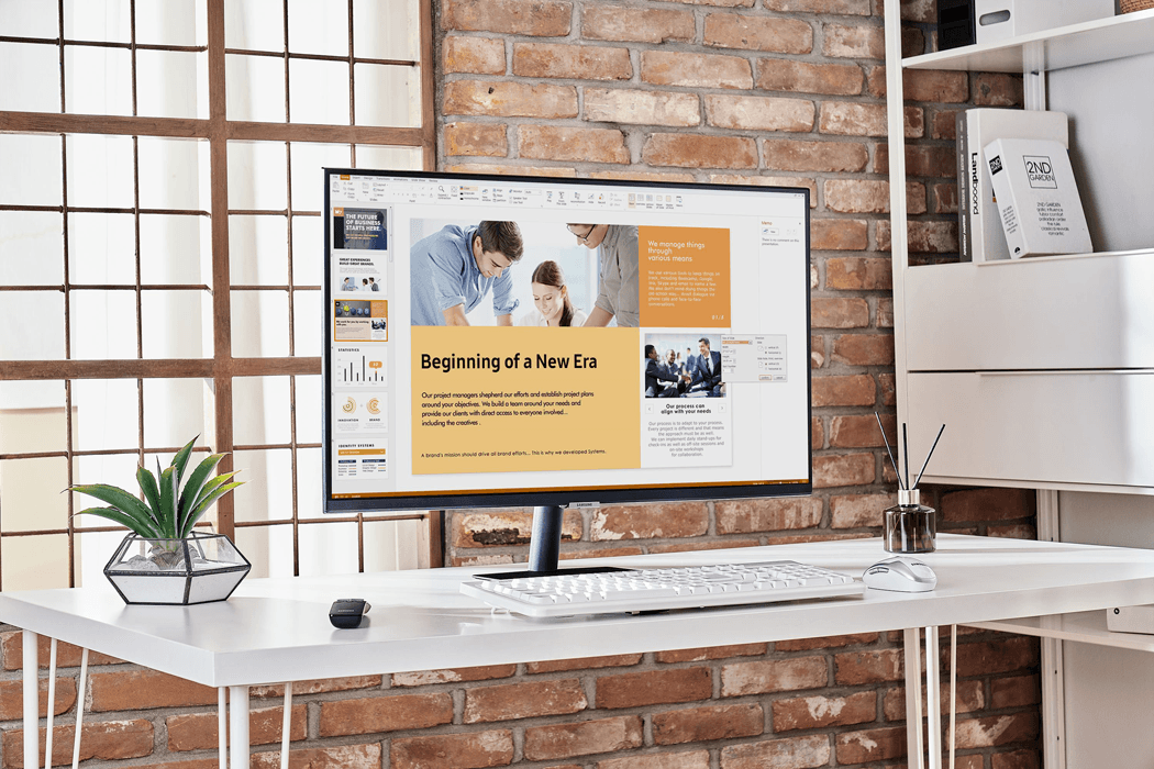 Smart Monitor Samsung affichant une présentation professionnelle sur un bureau blanc face à un mur de briques