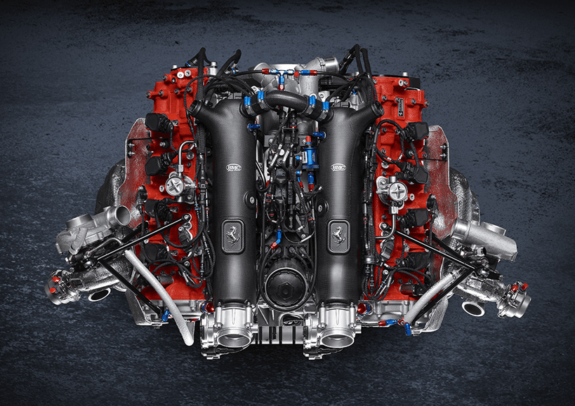 Moteur V12 biturbo Ferrari de la 488 GT Modificata avec blocs rouges, collecteurs chromés et tubulures bleues, vue de dessus