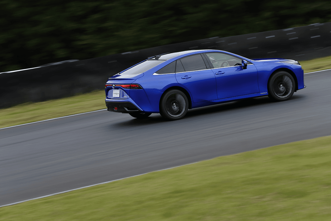 Toyota Mirai bleue en mouvement sur route, aux proportions élancées avec jantes de grande taille