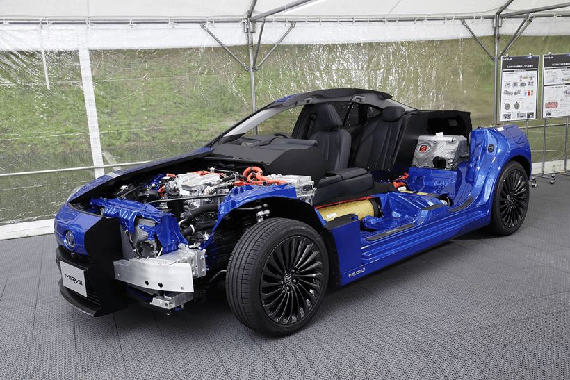 Toyota Mirai bleu avec le capot ouvert montrant le système de pile à combustible hydrogène et ses composants internes