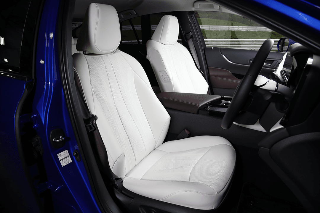 Intérieur de la nouvelle Toyota Mirai avec sièges avant blancs et garnitures marron, vue depuis la portière ouverte