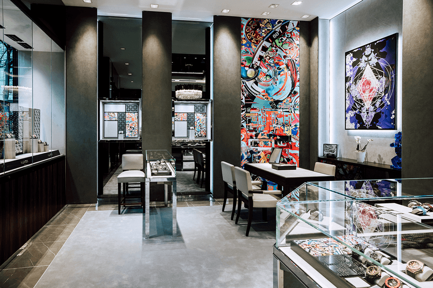 Intérieur de la boutique Hublot de Zurich avec murs noirs, œuvres d'art colorées, mobilier minimaliste et vitrines de montres