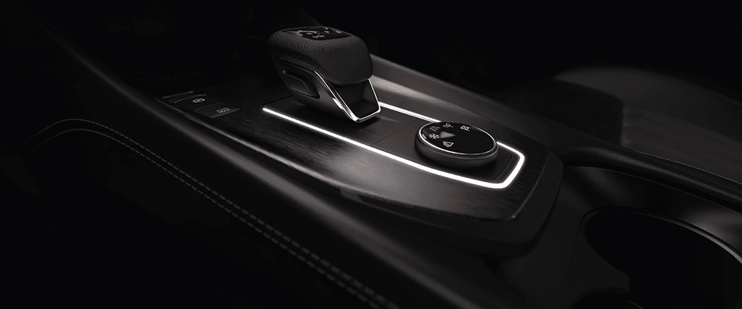 Nissan Qashqai, détail du levier de vitesses automatique et commandes du tableau de bord, intérieur noir épuré avec éclairage ambiant