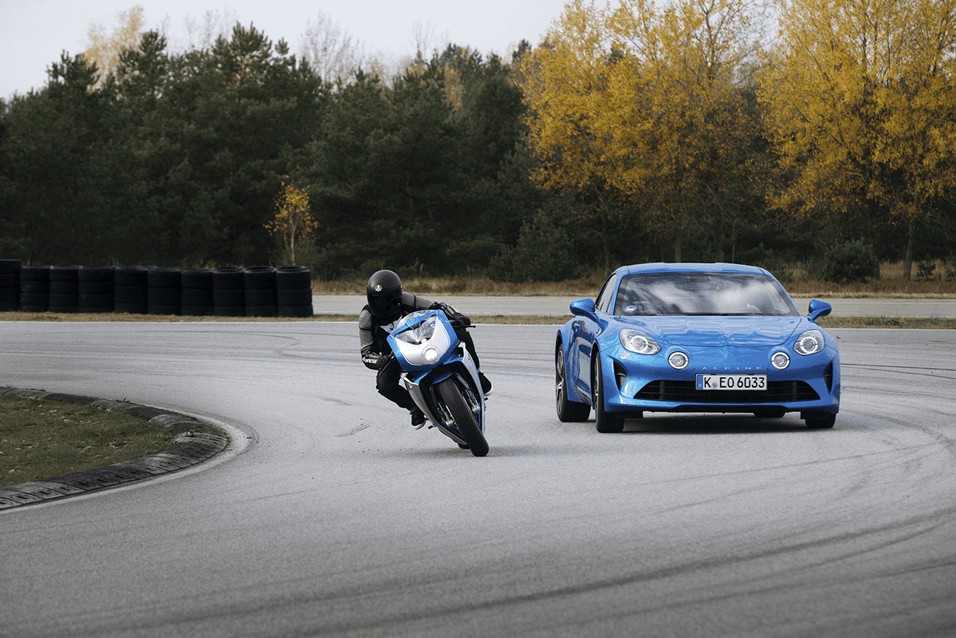 MV Agusta Superveloce blanche et noire roulant aux côtés d'une Alpine A110 bleue sur circuit