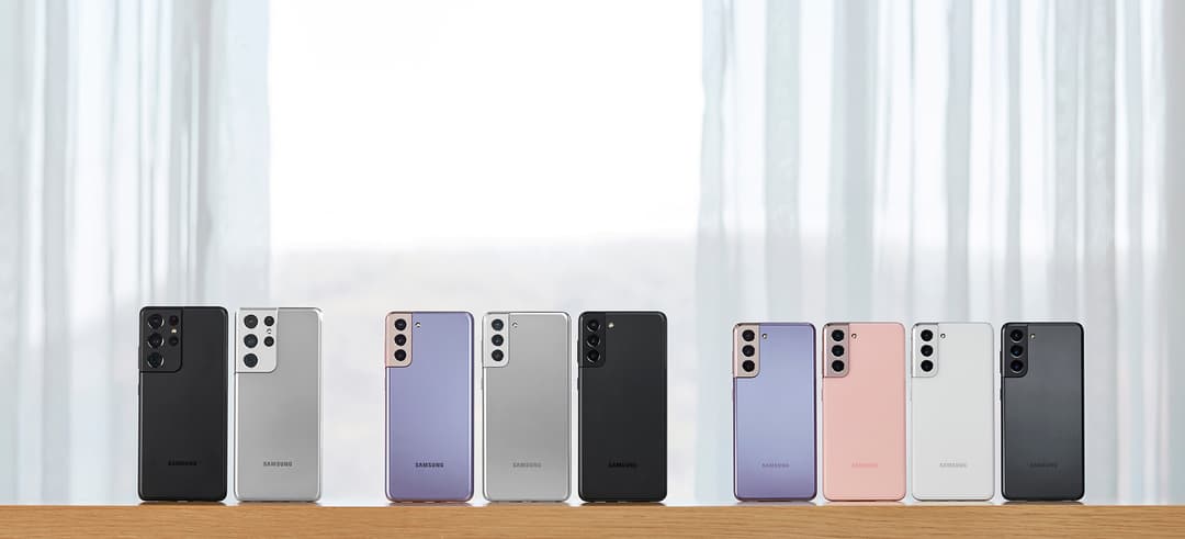 Neuf smartphones Samsung Galaxy S21 alignés, présentant différentes couleurs: noir, argent, violet, rose et blanc