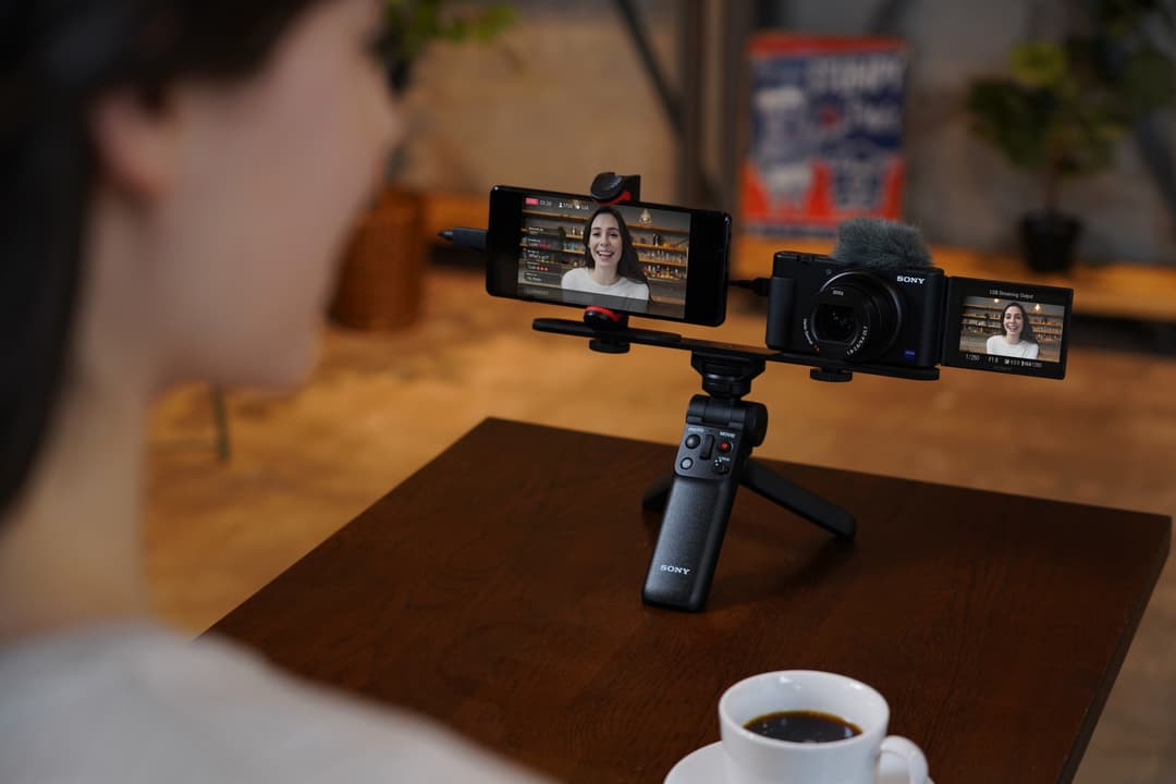 Sony ZV-1 monté sur un trépied avec smartphone et écran affichant une vidéo de livestreaming d'une femme