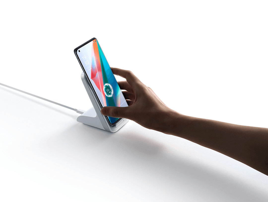 OPPO Find X3 noir tenu en main, affichant un écran coloré avec dégradé rouge, orange, bleu et vert
