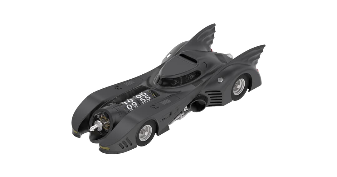 Horloge de table noire en forme de Batmobile de Tim Burton, avec ailes déployées et cadran affichant l'heure sur le flanc