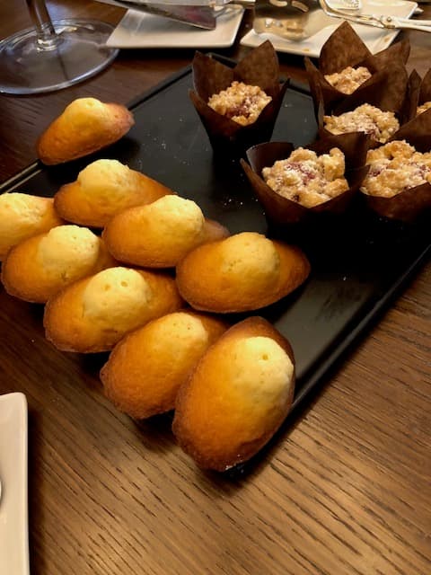 Plateau noir avec boules de Berlin dorées et petits gâteaux en caissettes au Beau-Rivage Palace