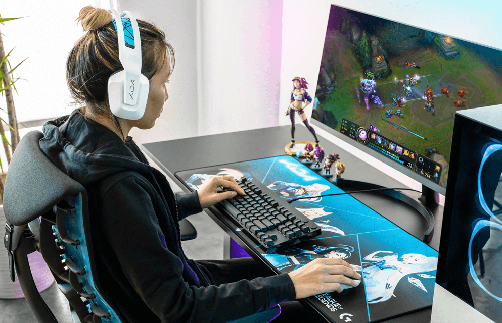 Personne portant un casque Logitech G733 K/DA blanc jouant à League of Legends avec clavier mécanique G PRO et souris, devant un écran affichant la partie en cours