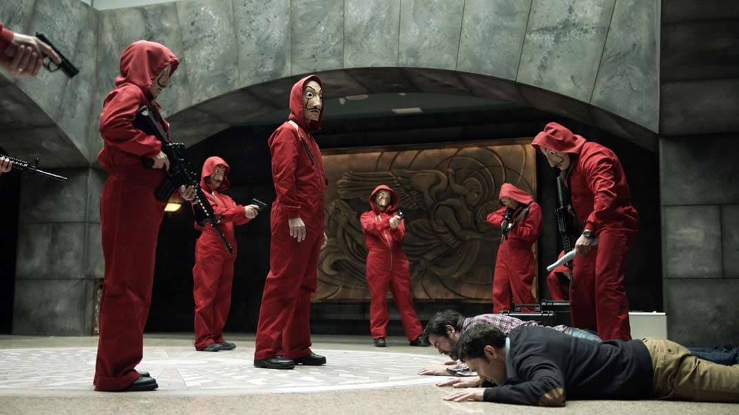 Braqueurs en combinaison rouge et masques tenant des otages à terre dans la Maison de la Monnaie