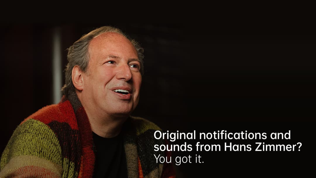 Hans Zimmer, compositeur, portant un pull coloré, sur fond noir avec texte promotionnel OPPO Find X3 Pro 5G
