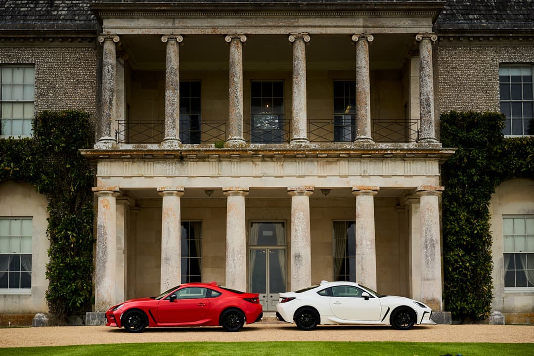 Toyota GR 86 rouge et blanche face à une façade classique avec colonnes au Goodwood Festival of Speed