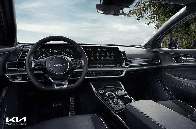 Habitacle du Kia Sportage avec volant de sport, large écran tactile central et système d'infodivertissement