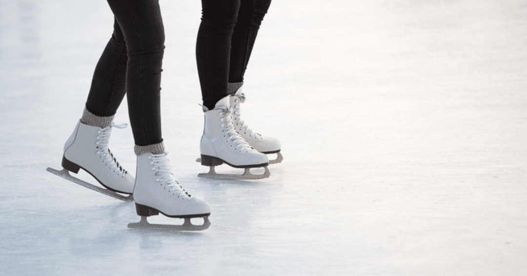 Deux paires de patins blancs sur la glace de la patinoire couverte de Vevey, au bord du lac