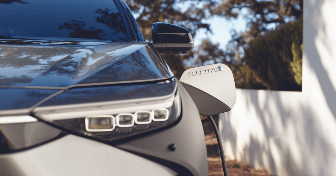 Toyota BZ4X blanc en gros plan, avec le mot « ELECTRIC » visible sur le rétroviseur