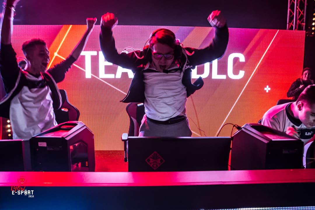 Équipe LDLC célébrant sa victoire à Lyon Esport 2018, les joueurs les bras levés devant un écran géant rose et rouge