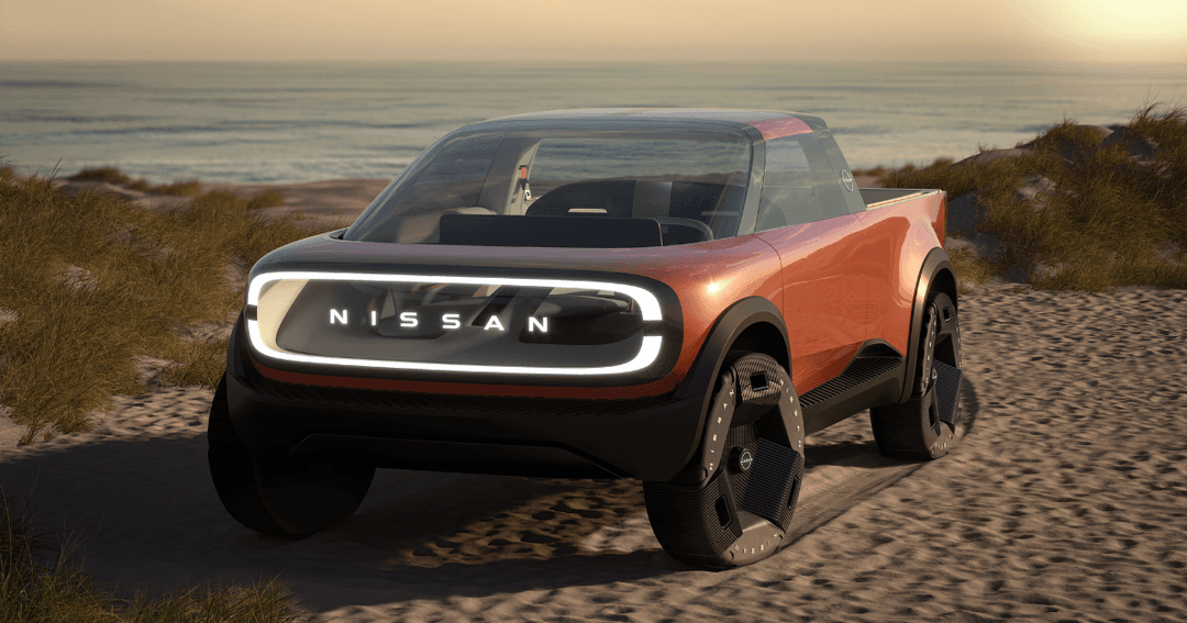 Concept-car Nissan rouge et noir avec grille de calandre illuminée, stationné sur une plage de sable au coucher de soleil