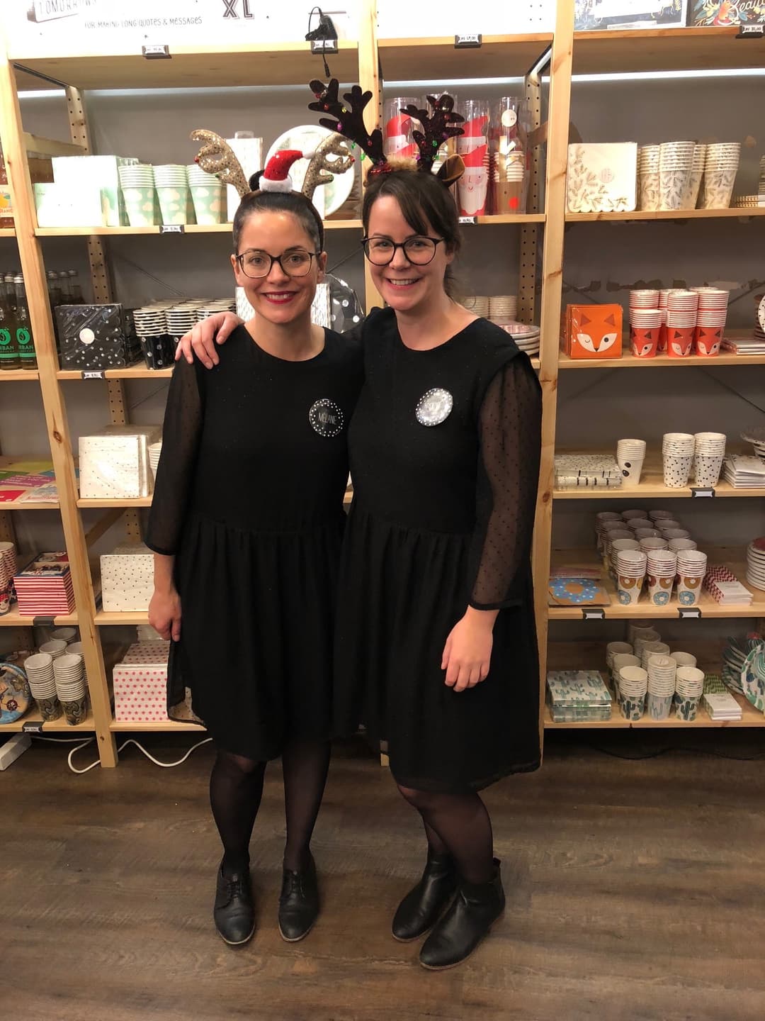 Mélanie et Soizic, les fondatrices du Royaume Melazic, sourient devant des étagères de produits de pâtisserie, portant des couronnes de rennes