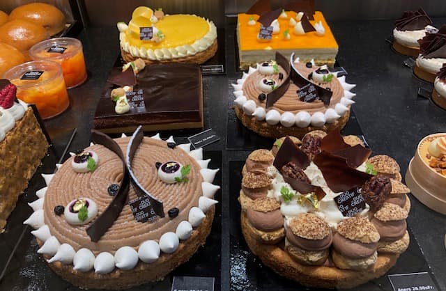 Vitrines de pâtisseries avec gâteaux, tartes et petits fours aux saveurs variées, fruits frais et décors colorés