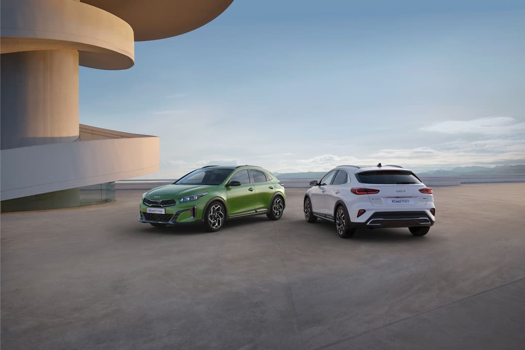 Deux Kia XCeed redessinés, l'un vert vif et l'autre blanc, stationnés sur une esplanade face à l'horizon