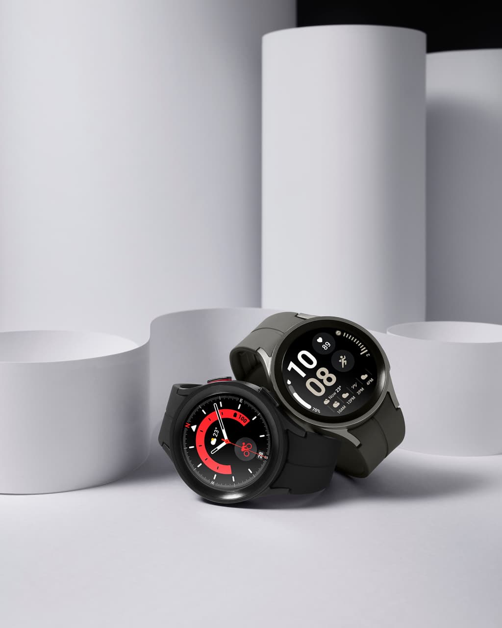 Deux Samsung Galaxy Watch5 noires côte à côte, l'une affichant l'heure analogique avec un cadran rouge, l'autre en mode numérique
