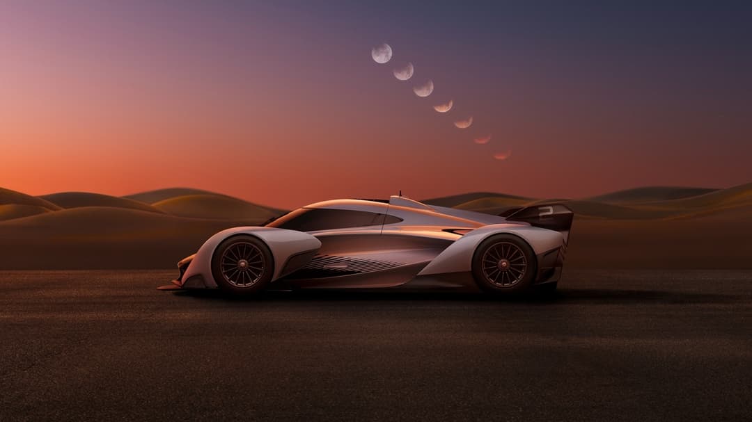 McLaren Solus GT blanche garée dans un désert aride au coucher de soleil, phases lunaires visibles dans le ciel orange