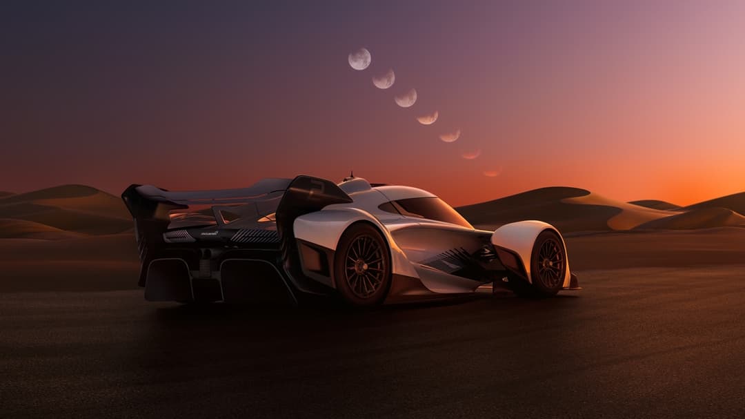 McLaren Solus GT blanc et noir garée dans un désert rocailleux au coucher de soleil orange