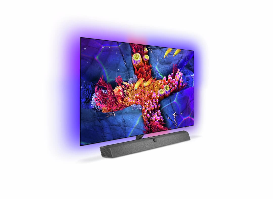 Téléviseur Philips OLED+937 affichant des coraux colorés, avec système Ambilight projetant une aura violette et rose autour de l'écran