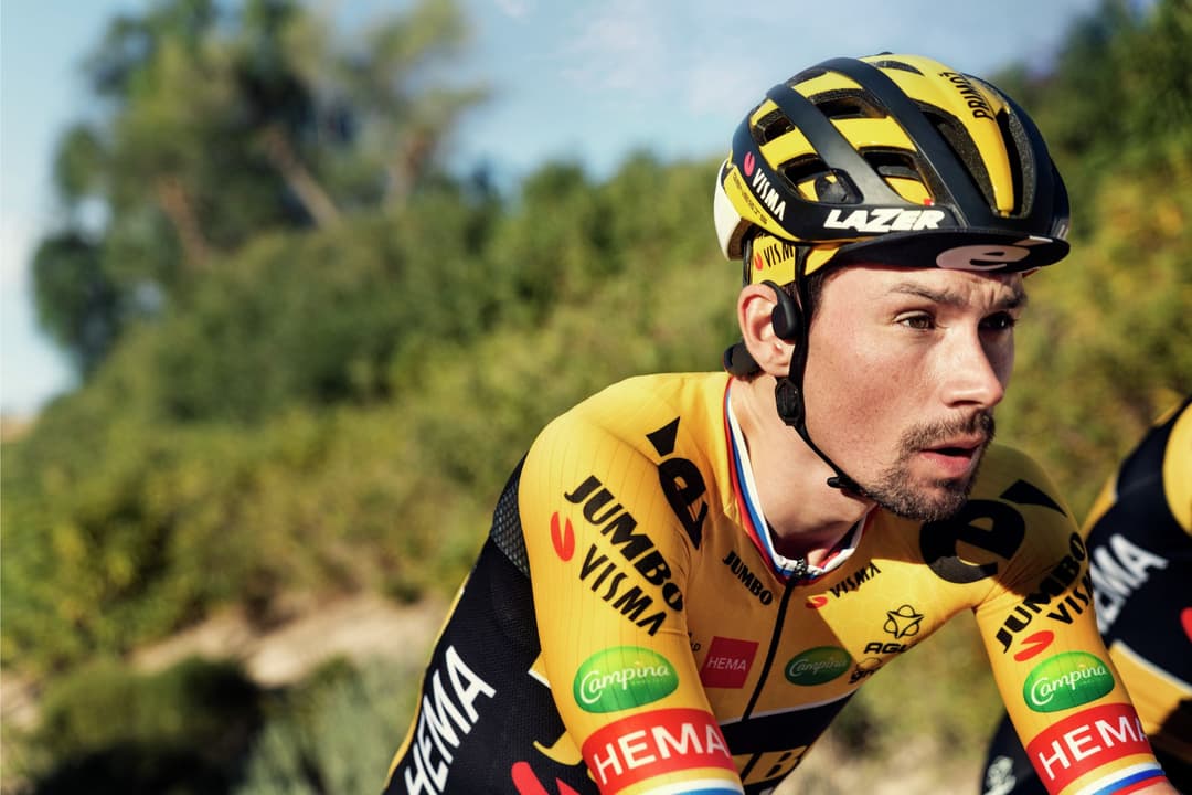 Cycliste de l'équipe Jumbo Visma en tenue jaune et noire portant un casque Lazer, équipé d'écouteurs Philips A7607 à conduction osseuse