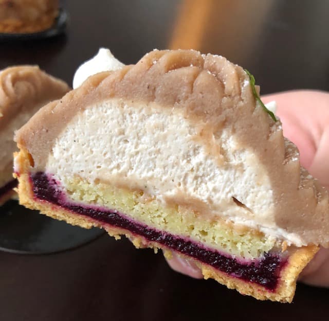 Tranche de gâteau moelleux garni d'une couche de fruits rouges et surmonté d'une mousse crémeuse beige