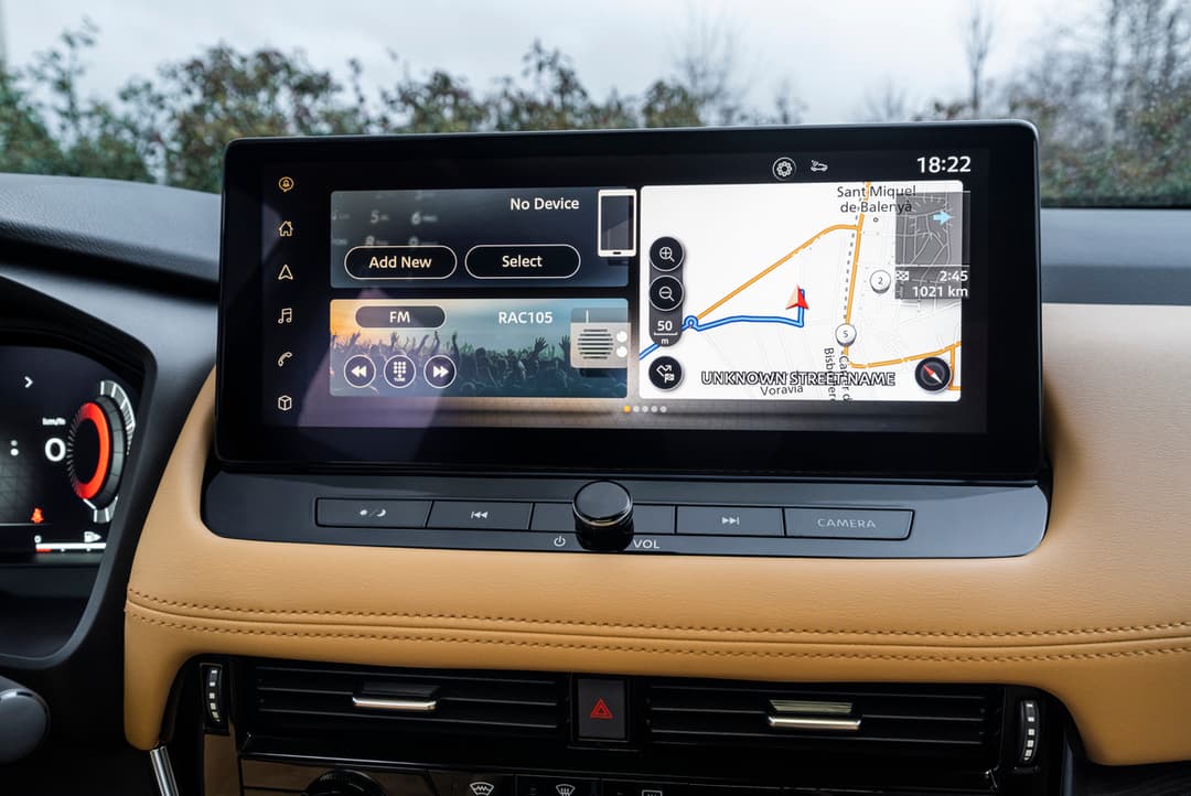 Écran tactile du Nissan X-Trail affichant un système de navigation avec carte routière, radio FM et interface de connectivité