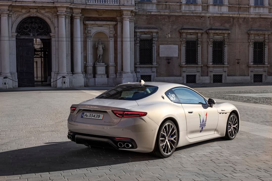 Maserati GranTurismo blanc avec logo familial devant un palais italien aux colonnes classiques