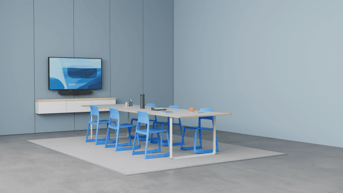 Salle de réunion hybride avec écran mural affichant un participant à distance et table équipée de la caméra Logitech Sight