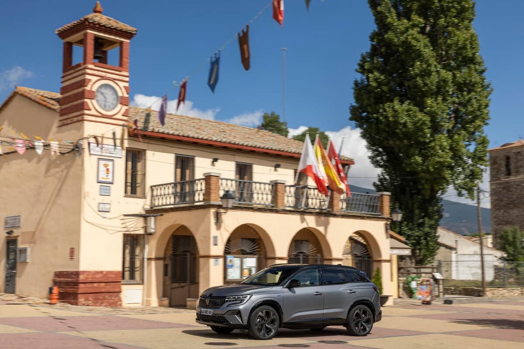 Renault Austral E-Tech full hybrid gris métallisé garé devant une mairie coloniale avec clocheton rouge et blanc