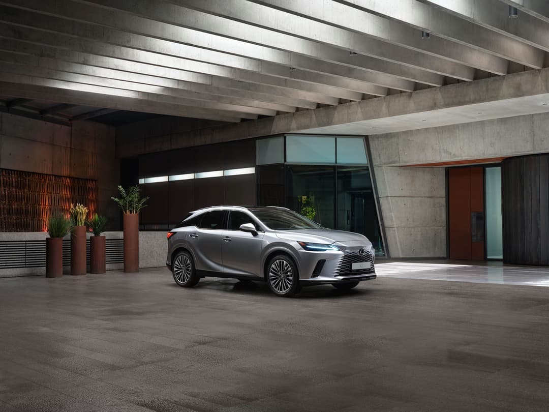 Lexus RX 450h+ gris stationnée dans un parking souterrain moderne aux murs béton et acier