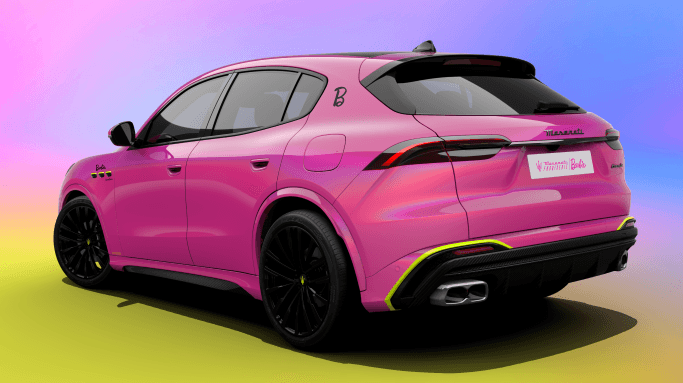 Maserati Levante rose vif personnalisée Barbie, vue de trois quarts arrière, sur dégradé de fond rose, bleu et jaune