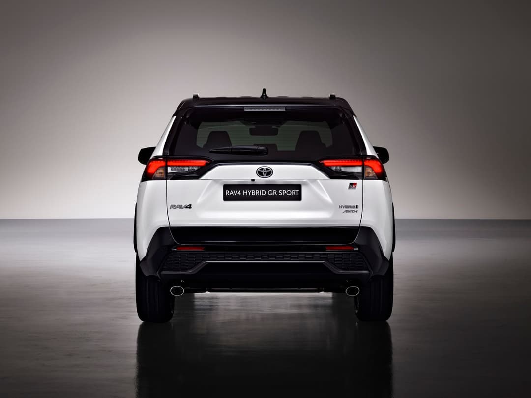 Toyota RAV4 Hybrid GR SPORT blanc vue de l'arrière, avec feux arrière rouges et logo GR SPORT visible