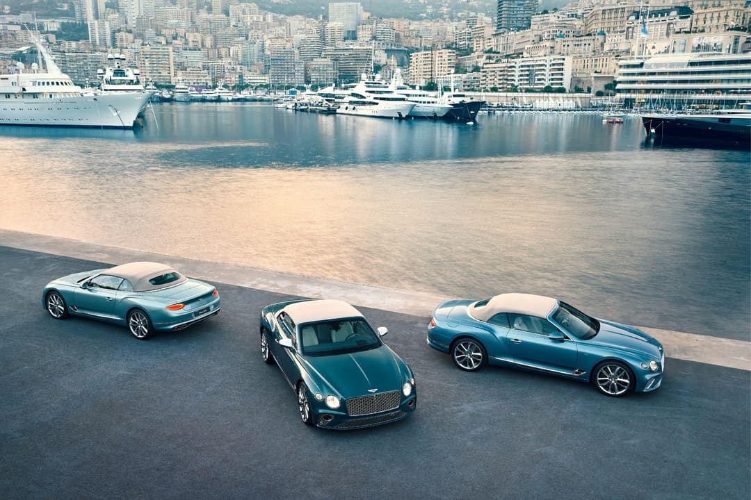 Trois Bentley de couleurs bleu turquoise et bleu-vert stationnées au bord de mer à Monaco, avec yachts de luxe amarrés en arrière-plan