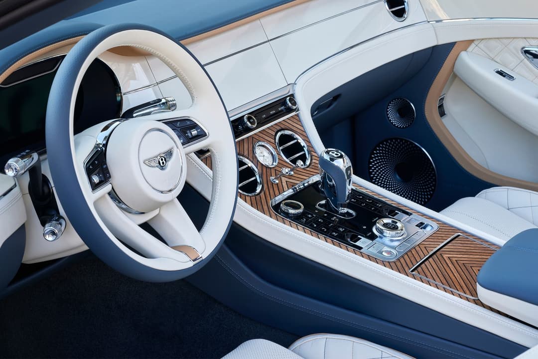 Habitacle du Bentley Continental GT Cabriolet Riviera aux teintes blanc et bleu, avec volant blanc et panneaux de bois