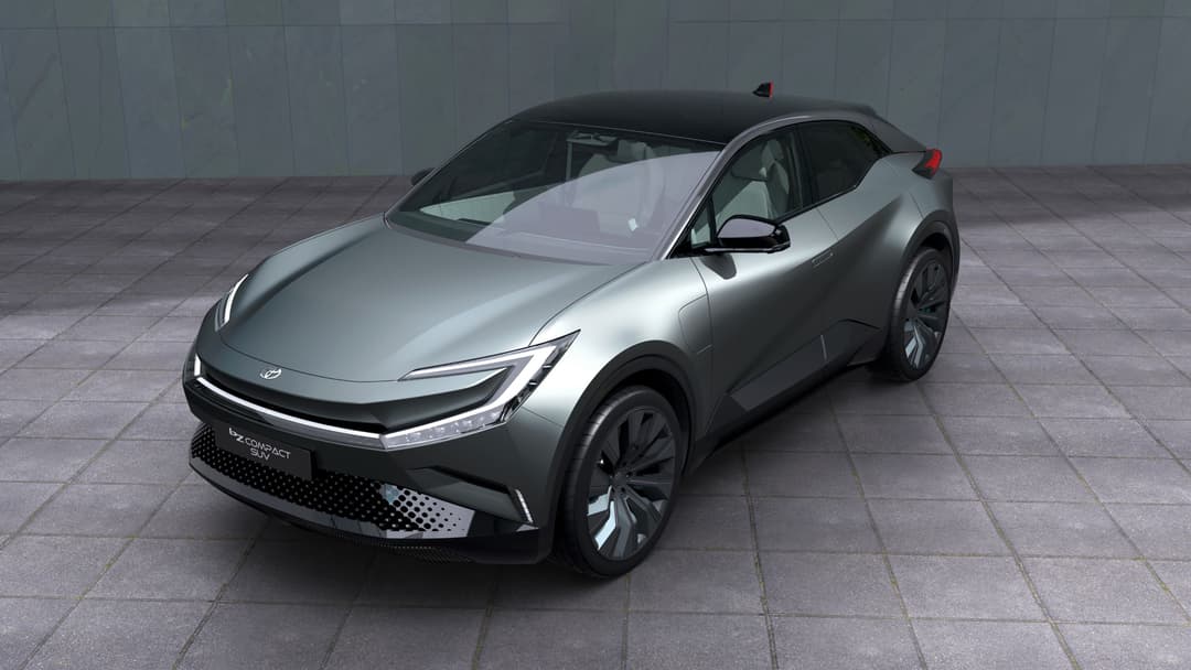 Concept Toyota bZ Compact SUV gris argent aux lignes épurées, vue de trois quarts, sur fond de bâtiment gris