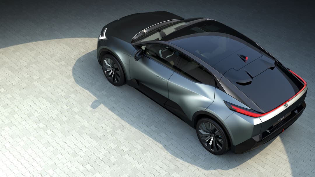 Toyota bZ Compact SUV concept au design minimaliste, gris et noir, porte ouverte, vue de trois-quarts de dessus sur sol clair