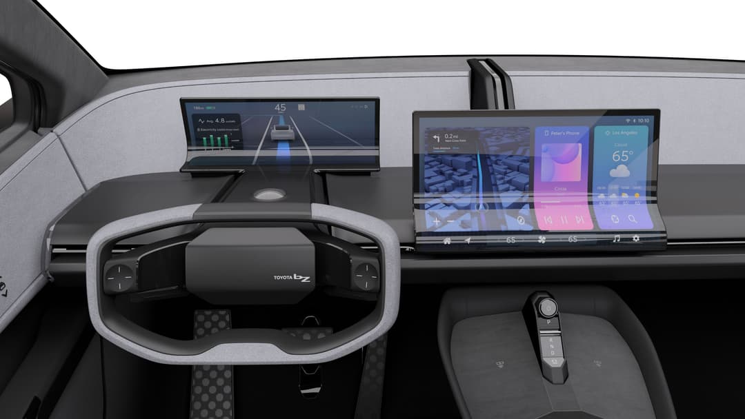 Habitacle du Toyota bZ Compact SUV avec volant futuriste, écrans numériques et interfaces tactiles minimalistes