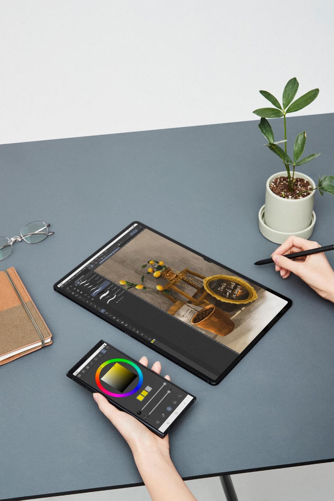 Galaxy S22 Ultra et Galaxy S22 affichant des outils d'édition photo et vidéo, posés sur un bureau avec plante et accessoires