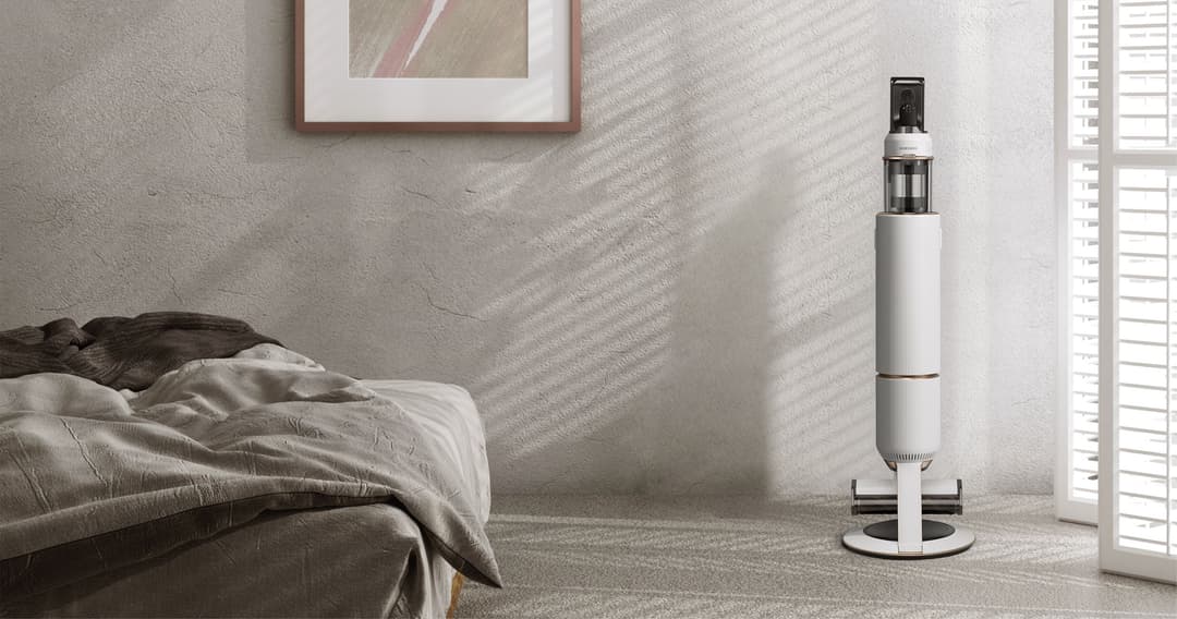 Purificateur d'air Samsung blanc et noir posé sur le sol d'une chambre minimaliste aux murs gris clair