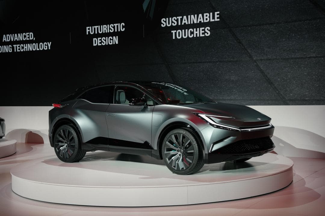 Toyota BZ Concept SUV argenté présenté sur un podium blanc, design futuriste avec phares épurés et jantes aérodynamiques