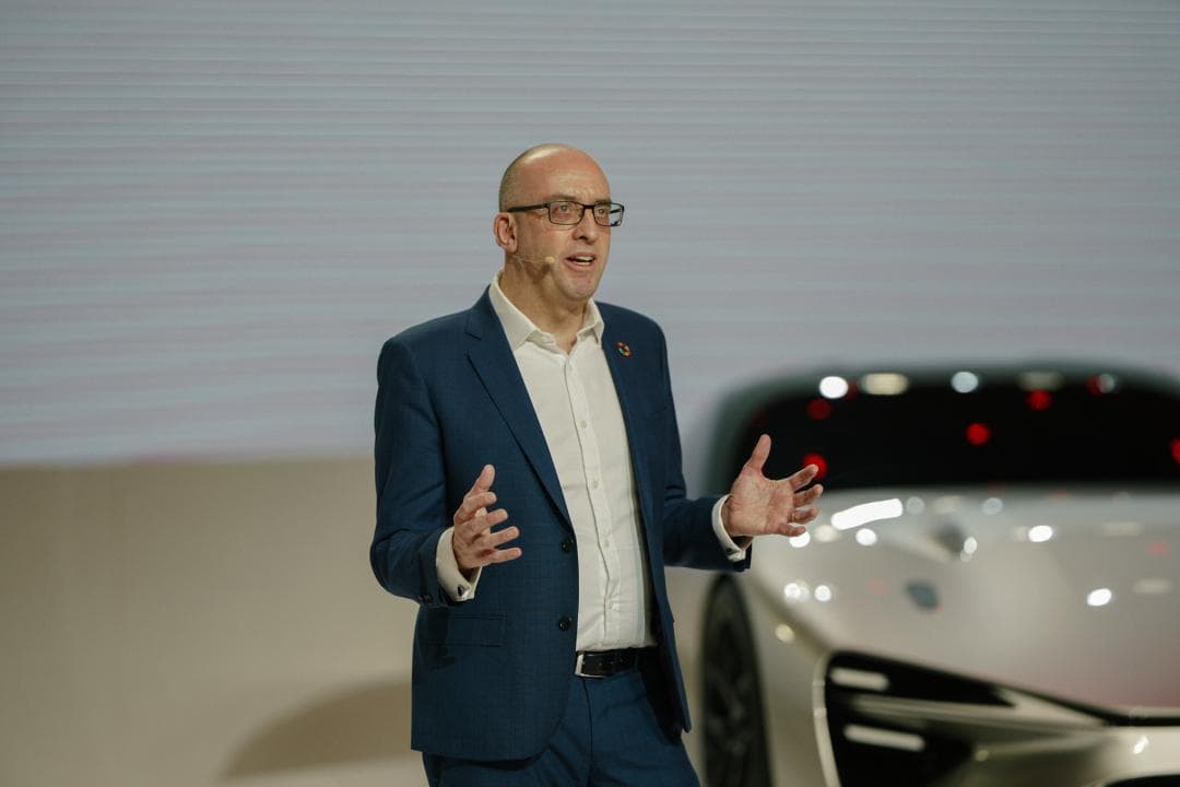 Marvin Cooke, EVP Manufacturing de Toyota Motor Europe, en costume bleu, parlant devant une automobile